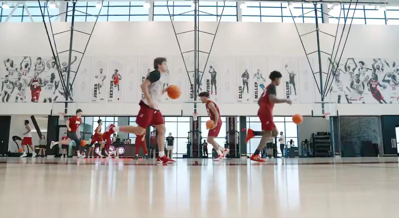 Alabama players running drills in the practice facility